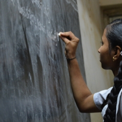 Student writing on chalkboard